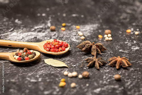 Various spice mixes in wooden spoons on black stone background. Selective focus.