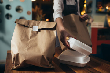 woman waitress preparing take away food in restaurant