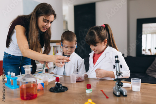 children with their mother do chemical experiments from kitchen ingredients at home