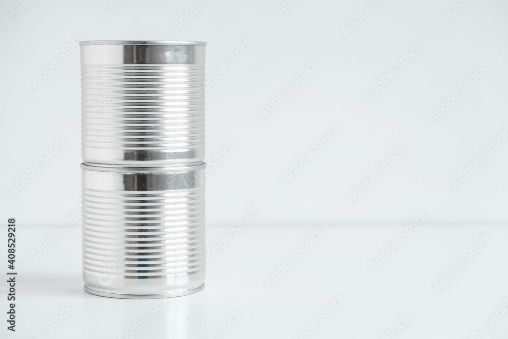 Two aluminum closed metal cans on a white table. Copy, empty space for text Two aluminum closed metal cans on a white table. Copy, empty space for text