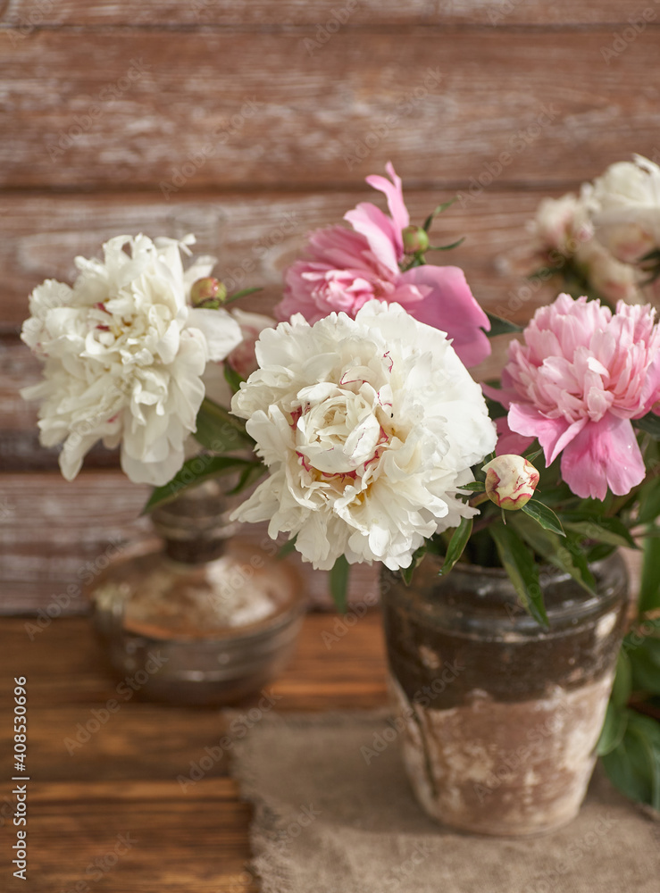 Still life with white and pink peonies in a old ceramic vase on wooden background Still life with white and pink peonies in a old ceramic vase on wooden background