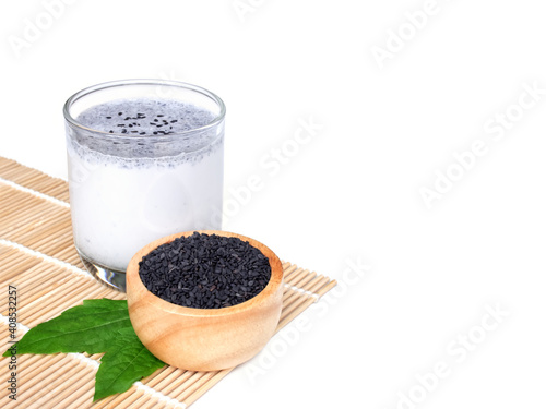 Soy milk mixed black sesame in clear glass and, Black sesame in wooden bowl isolated on white background with copy space, Healthy drink and health care concept.