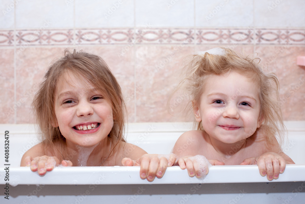 Little sisters bathing and smiling in bubble bath Little sisters bathing and smiling in bubble bath