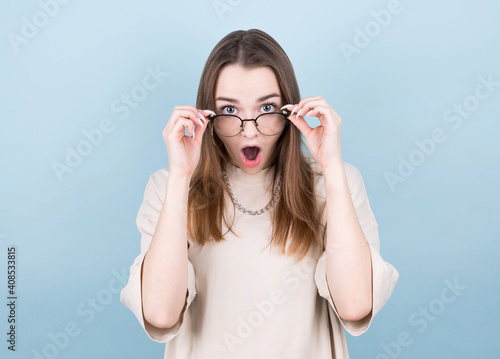 Canvas Print Wow! Shocked pretty woman touching her glasses.