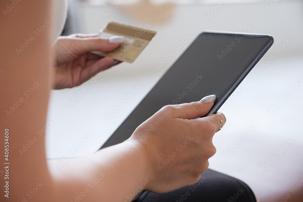 Brunette Caucasian woman in white blouse and dark skirt making an order via internet and pay using credit card. Online shopping concept. Space for text Brunette Caucasian woman in white blouse and dark skirt making an order via internet and pay using credit card. Online shopping concept. Space for text