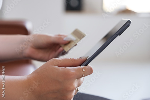 Brunette Caucasian woman in white blouse and dark skirt making an order via internet and pay using credit card. Online shopping concept. Space for text
