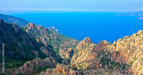 Aerial view of beautiful view of sunlit red mountains and the Mediterranean Sea with the Bay of Porto in Calanches area on Corsica island. Tourism and vacaions concept.
