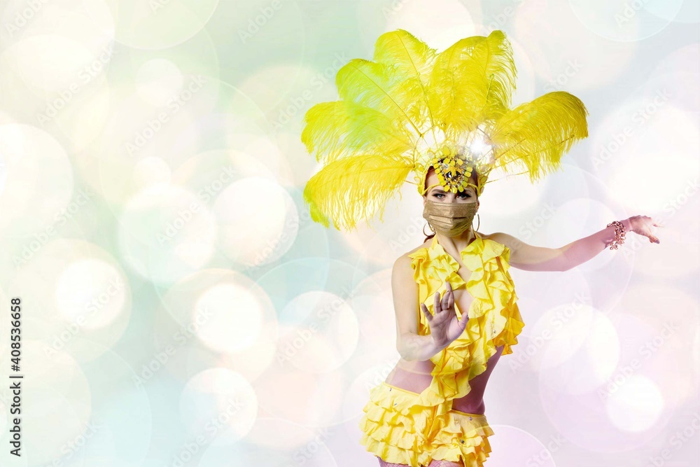 Fototapeta premium Beautiful young woman in carnival, stylish masquerade costume with feathers and golden face mask dancing on white background with shining neoned bokeh. Concept of celebration, festive time, party.