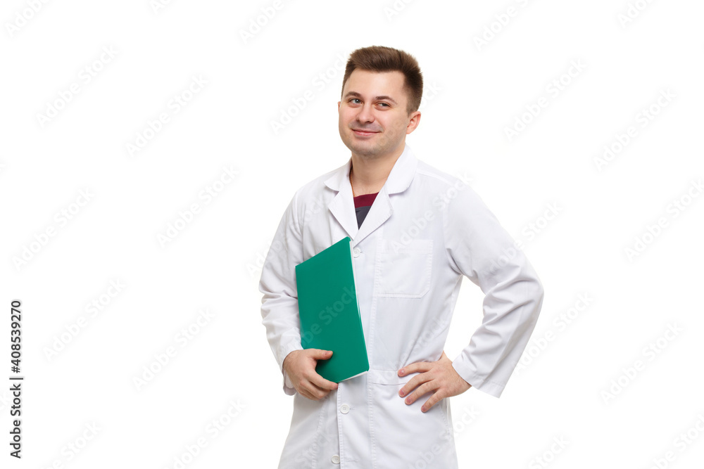 Young handsome doctor in a white coat holding a green folder isolated on a white background.