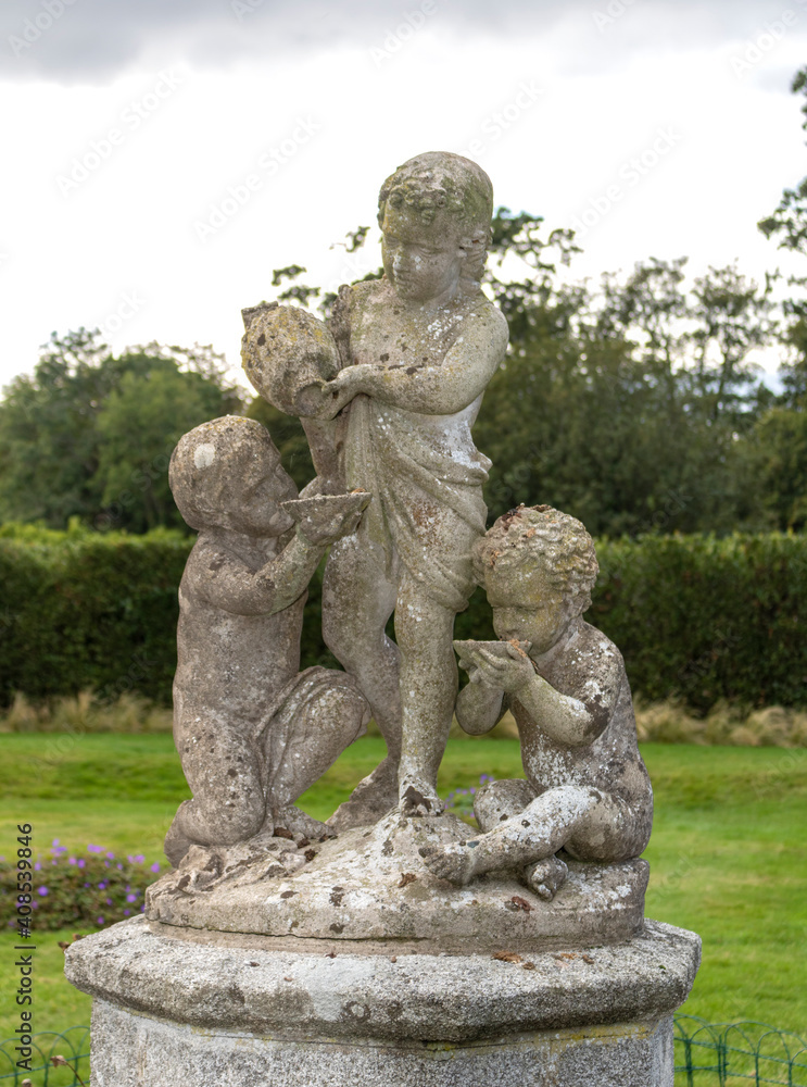 Sculptural composition of three children in the garden 