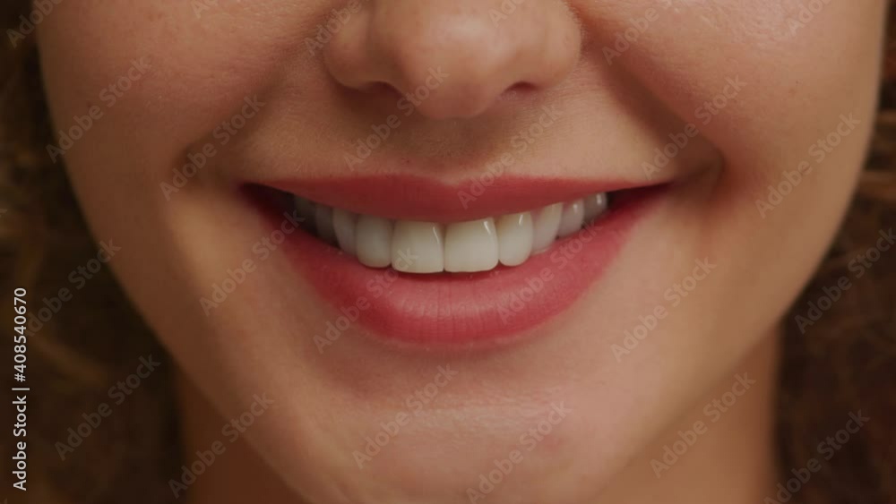 Close up of a charming woman smile with perfect natural teeth and bright lipstick Close up of a charming woman smile with perfect natural teeth and bright lipstick