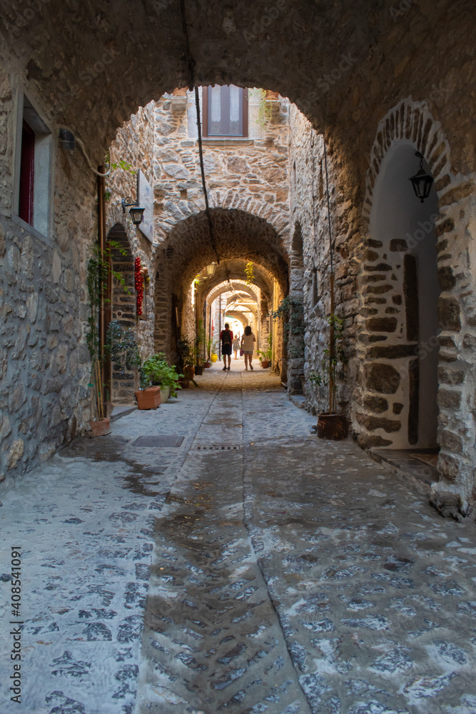 Couple walking on stone alley of Pirgi Village at Chios island