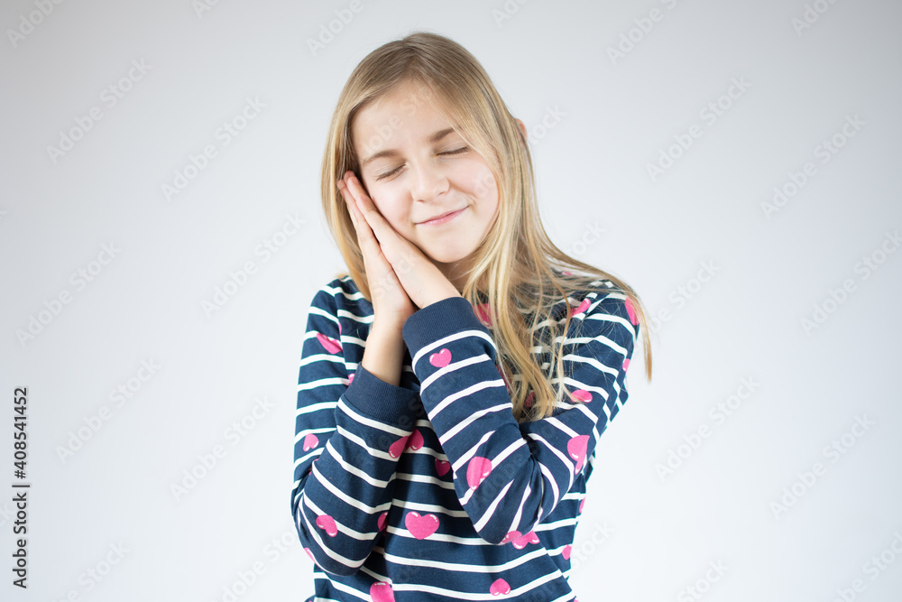 Portrait of cute little sleepy girl stands over white background with closed eyes and makes sleeping gesture. Portrait of cute little sleepy girl stands over white background with closed eyes and makes sleeping gesture.