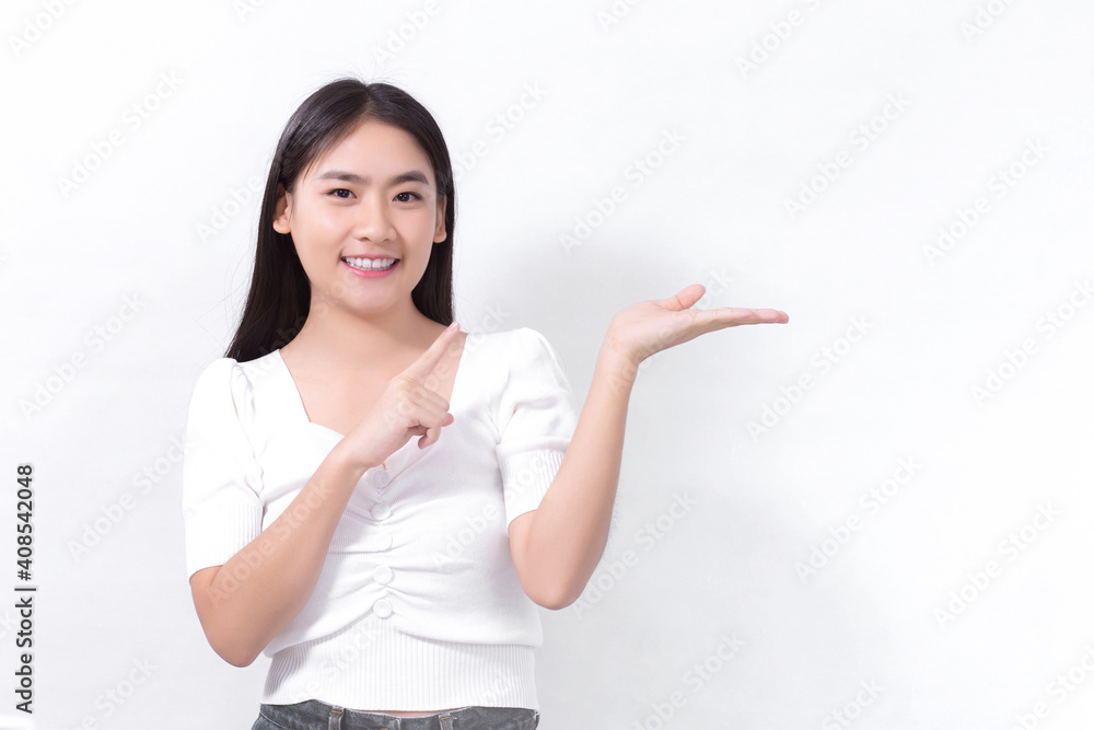 Asian woman in black long hair wears white shirt and shows point up to present something on white background. Asian woman in black long hair wears white shirt and shows point up to present something on white background.