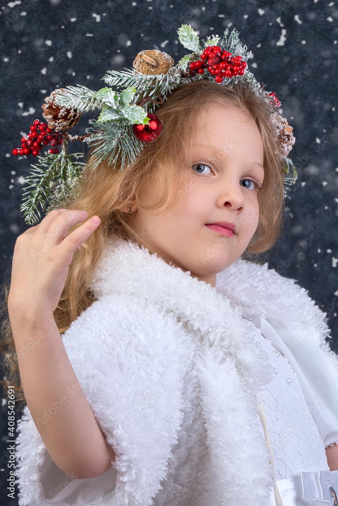 Beautiful little girl with a Christmas wreath on her head. Christmas child. Beautiful little girl with a Christmas wreath on her head. Christmas child.