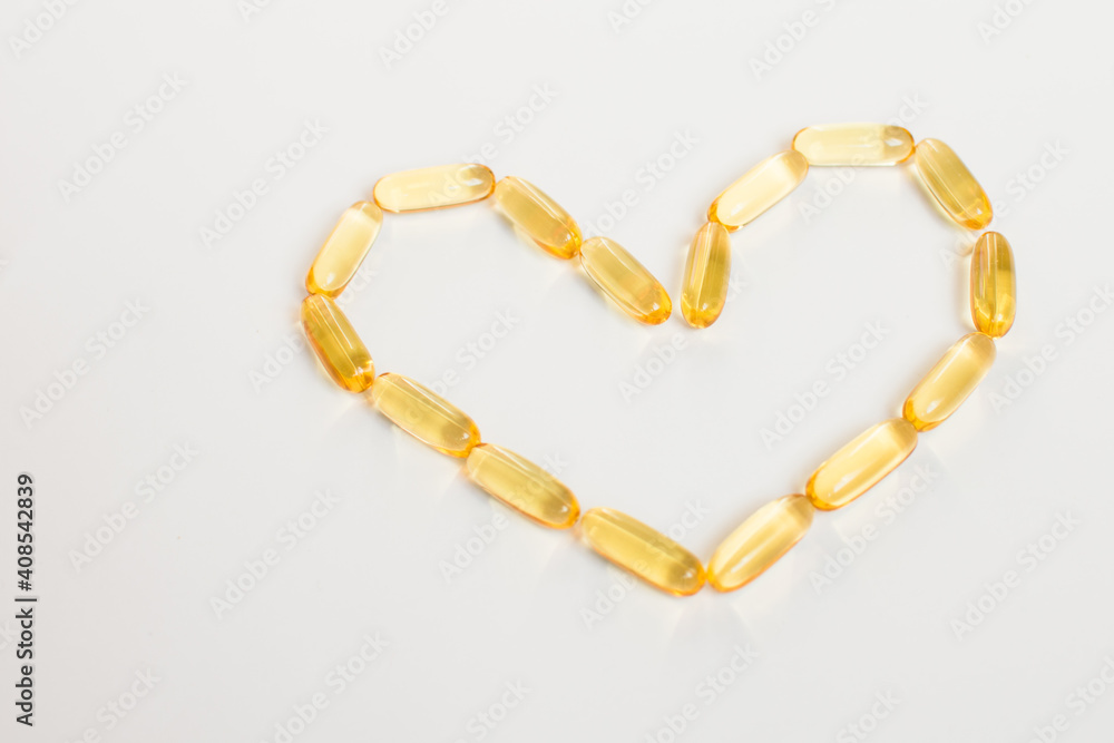 Heart shape made of cod oil capsules. Valentines day and healthy heart concept. Heart shape made of cod oil capsules. Valentines day and healthy heart concept.