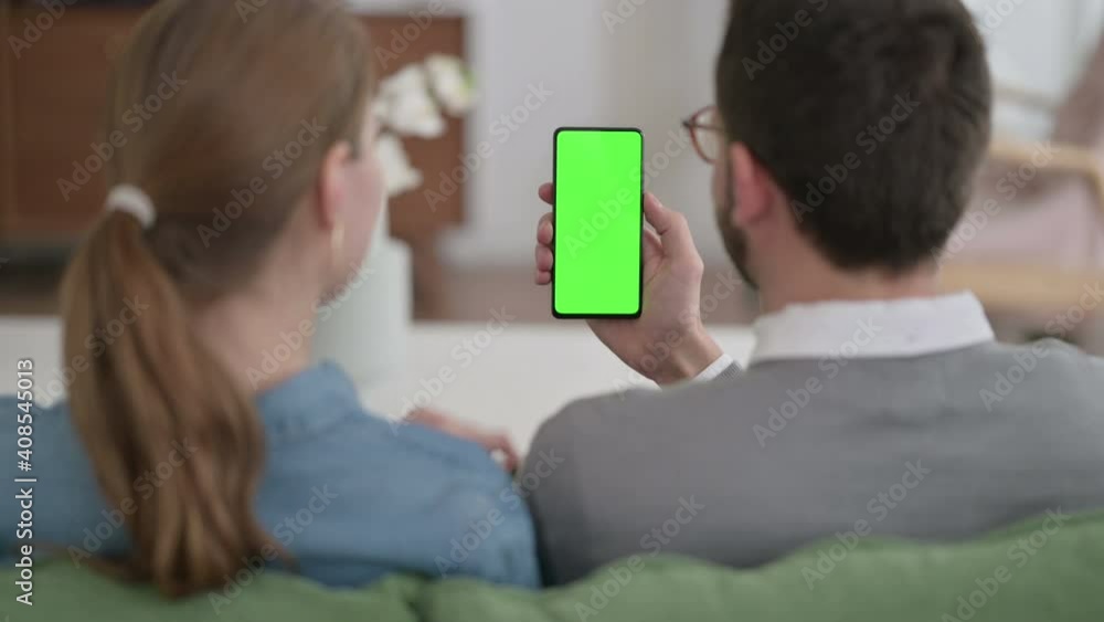 Rear View of Couple using Smartphone with Green Chroma Key Screen Rear View of Couple using Smartphone with Green Chroma Key Screen