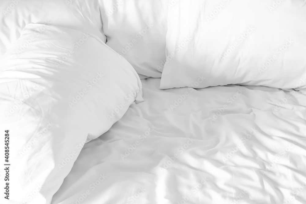 Obraz premium White mattress and pillows in the bedroom with space for a copy.