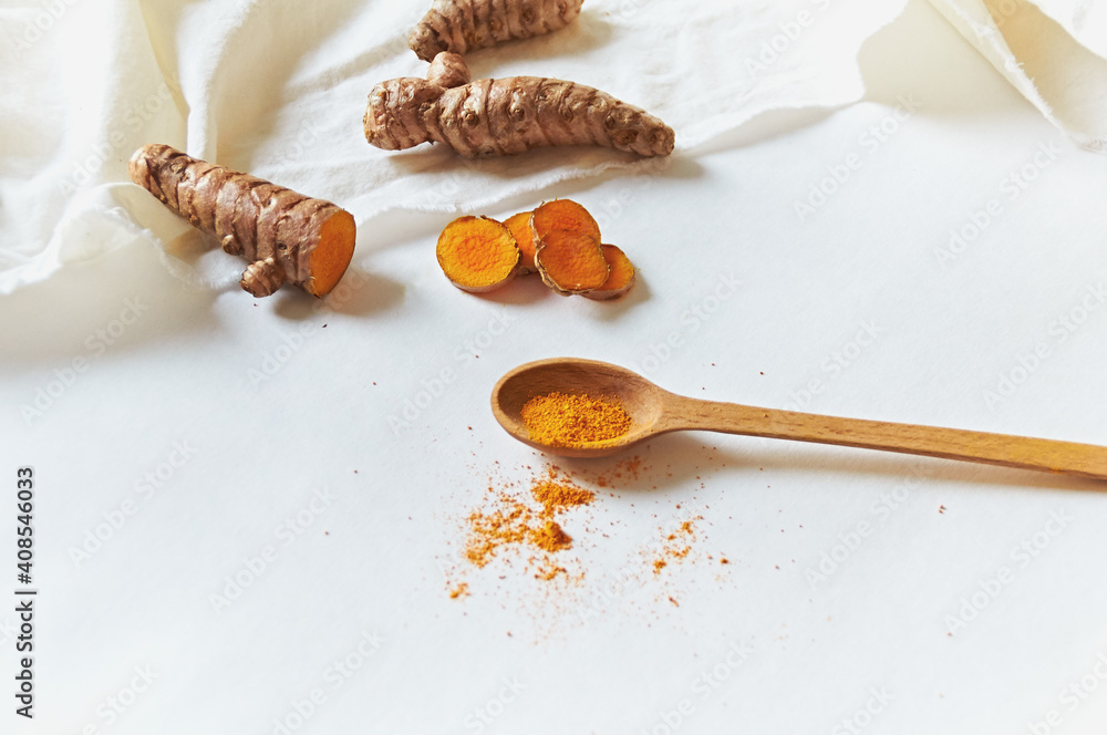Fototapeta premium Curcumin in a wooden spoon on a white background. Curmin root
