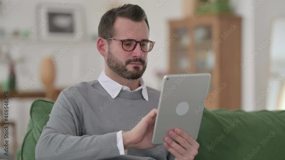 Middle Aged Man using Digital Tablet at Home Middle Aged Man using Digital Tablet at Home
