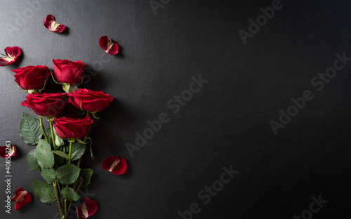 Love and Valentine's day concept made from red rose on black wooden background. Top view with copy space, flat lay.