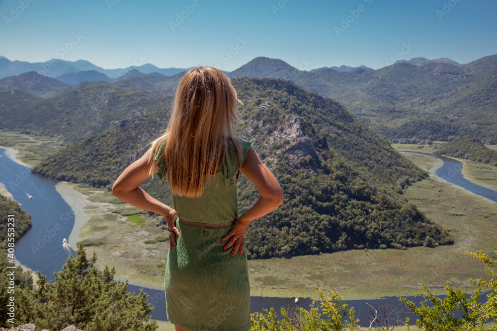 Woman standing on a rock and looking out at Skadar lake in Montenegro amazing travel destination in the Balkans.