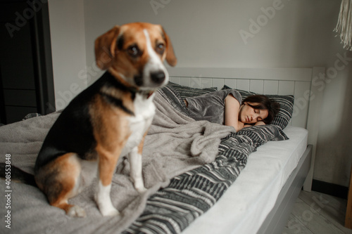 young woman with a dog on the bed in the bedroom