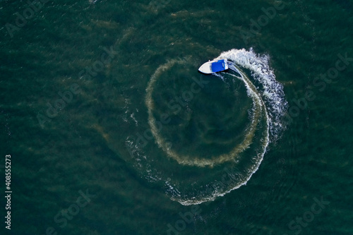 Aerial top view of a white pleasure boat on a summer day. Powerboat. Boat loop on the sea.