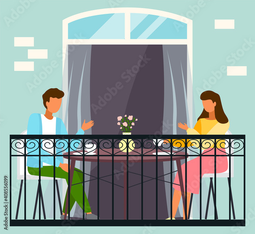Lovers on a date in a restaurant. Married couple celebrate the holiday together at home on the balcony. Man and woman sitting at the table and drinking tea. Nice family evening in quarantine time