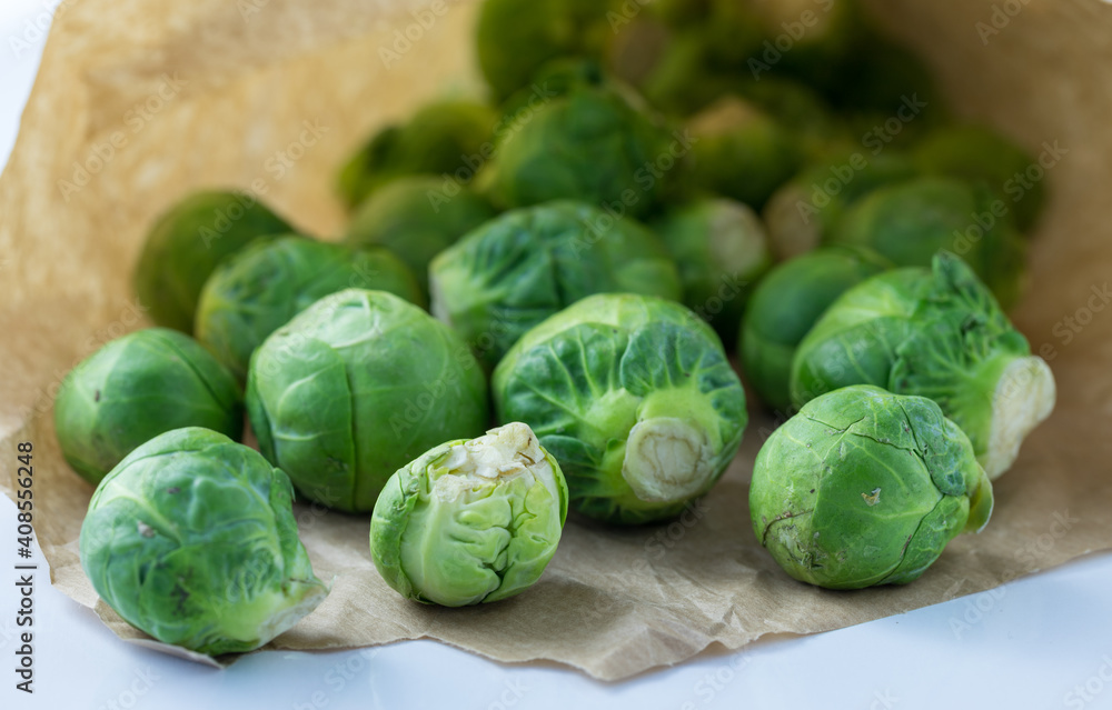 Portion of green brussels sprouds in a paper bag on a table Portion of green brussels sprouds in a paper bag on a table