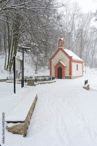 Small chapel and the Amber Fountain (Holy Fountain) Szent-kút (Borostyán-kút) Chapel near the Hungarian village Bakonybél in Hungary during a heavy snowfall. © fazon