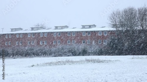 Snowfall over fields and buildings England UK (ID: 408557841)