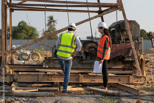 Φωτογραφία Beautiful female engineer with a male foreman wearing a protective helmet Talk about working problems, meeting together construction projects