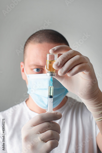 Concept fight against virus covid-19 corona virus, doctor or nurse or scientist in laboratory holding a syringe with liquid vaccines. 