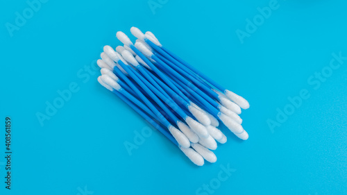 Ear cleaning sticks on a blue background.