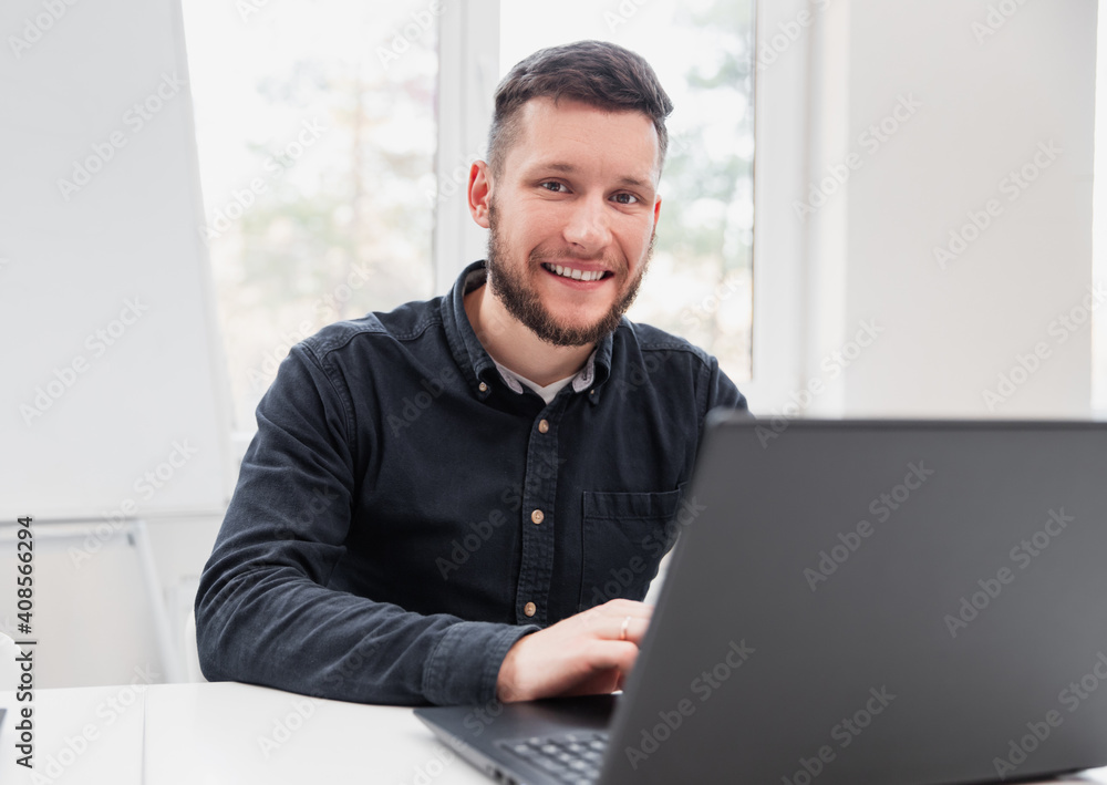 Happy male freelancer using laptop