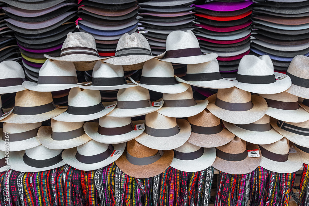 Stand with Panama hats and colorful wristbands for sale on Otavalo art and craft market, Ecuador.