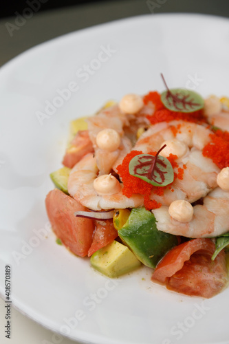 Shrimp with tomato, avocado, pickled onion and flying fish roe. Shrimp salad close-up.