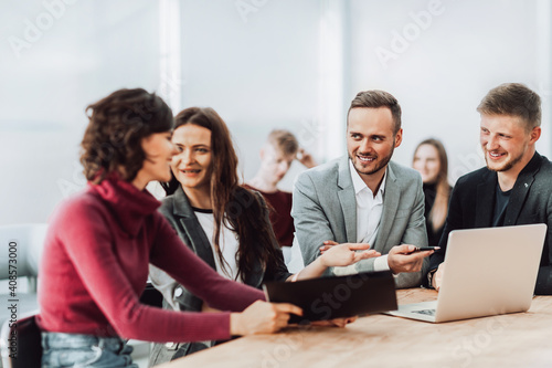 employees discuss working documents sitting at a Desk