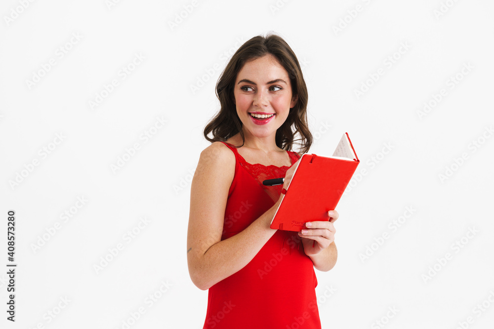 Happy beautiful girl writing down notes in planner