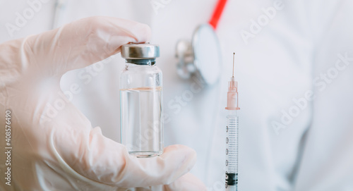 Covid 19 Vaccine in glass vial bottle, medicine liquid in doctor hand in glove with stethoscope. Vaccination injections as treatment. Covid 19 immunization concept. Long web banner