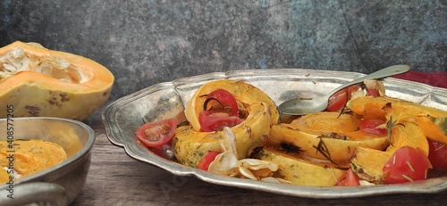 Roasted slices of pumpkin and cherry tomatoes on a silver tray