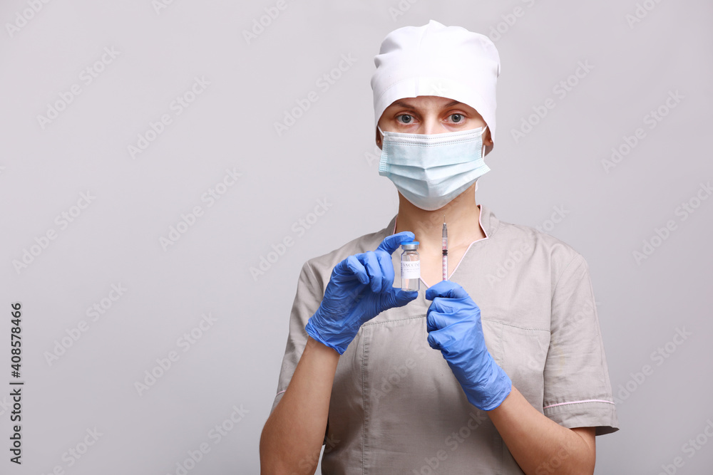 Doctor, nurse in medical mask and gloves holding flu, measles, coronavirus, covid-19 vaccine disease preparing for human clinical trials vaccination shot, medicine and drug concept. Doctor, nurse in medical mask and gloves holding flu, measles, coronavirus, covid-19 vaccine disease preparing for human clinical trials vaccination shot, medicine and drug concept.
