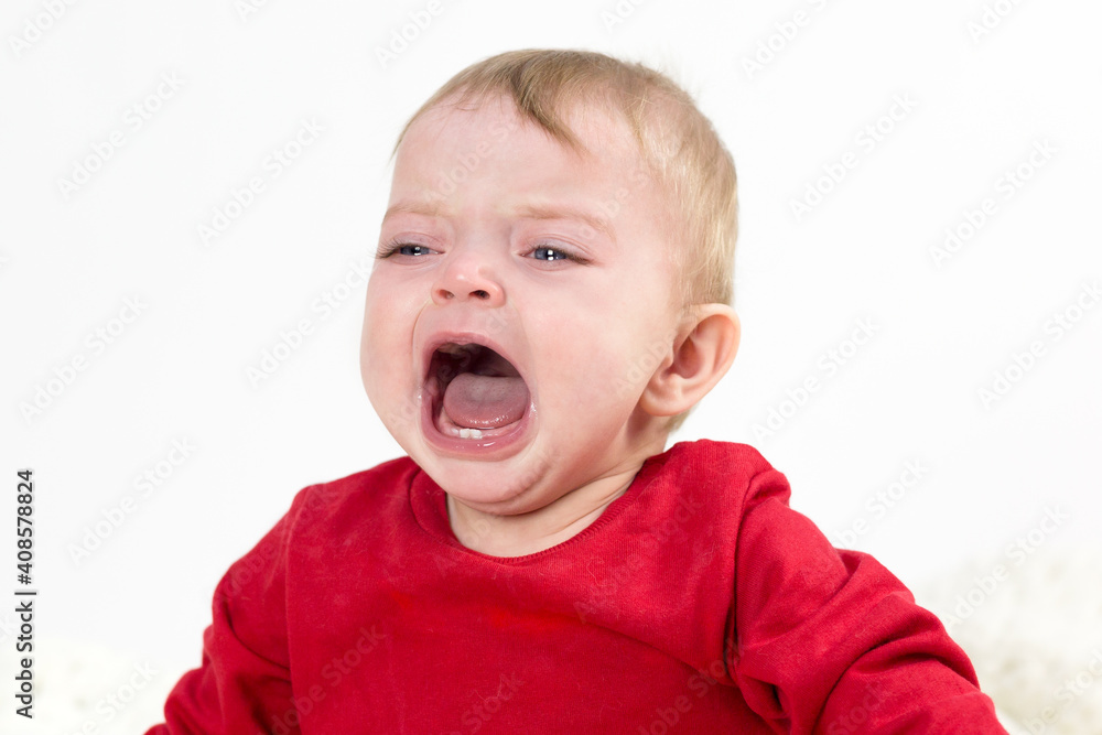 A child with tears in his eyes is crying loudly with his mouth wide open. A child with tears in his eyes is crying loudly with his mouth wide open.