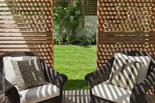 Rattan furniture in a slatted cedar garden pavilion photo