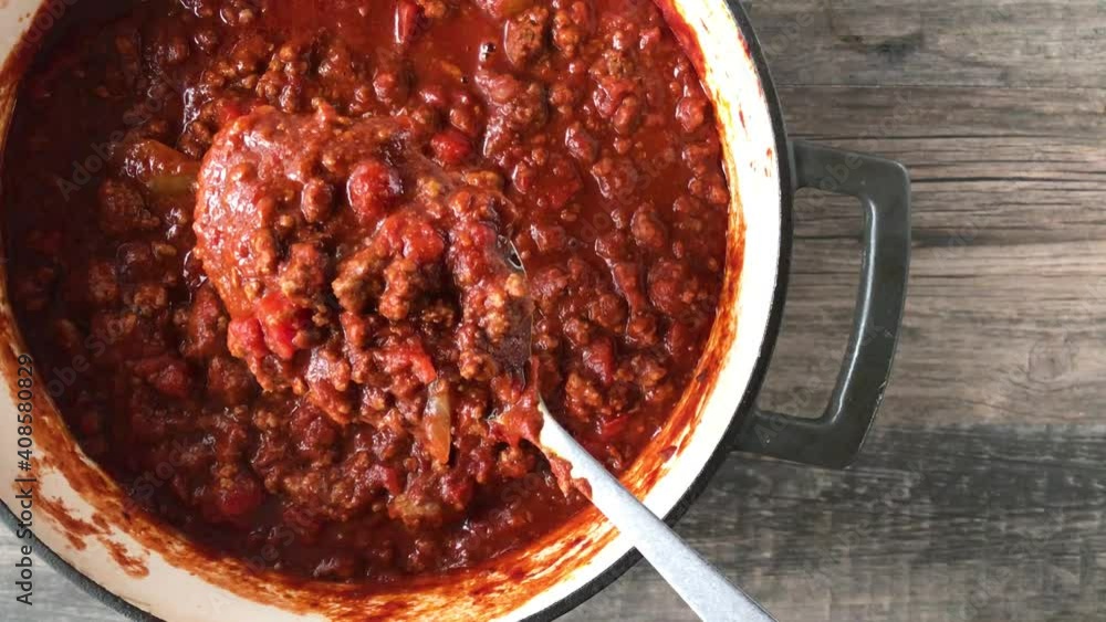 top view of big pot of bean-less chili with lifted spoonful top view of big pot of bean-less chili with lifted spoonful