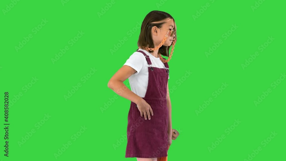 Casual young girl in shades holding a skateboard posing on a Green Screen, Chroma Key. Casual young girl in shades holding a skateboard posing on a Green Screen, Chroma Key.