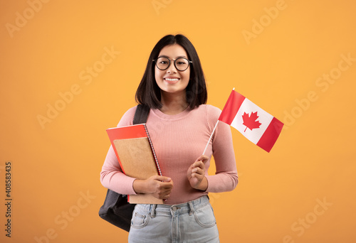 Travel, modern education and student exchange. Young cheerful asian woman in glasses with notebooks