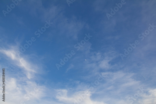 blue sky with clouds and a moon