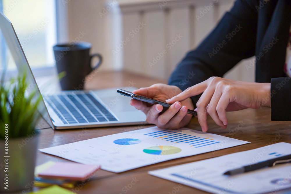 Close up hand of Business Women using PC, calculator, Profit chart sheet and writing make note with calculate about cost at home office. Close up hand of Business Women using PC, calculator, Profit chart sheet and writing make note with calculate about cost at home office.